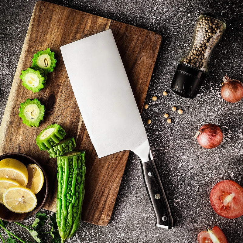 Knife on a wooden cutting board with vegetables and spices on a dark surface