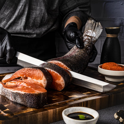 Person cutting a salmon fillet on a wooden board with a knife, surrounded by bowls of ingredients.