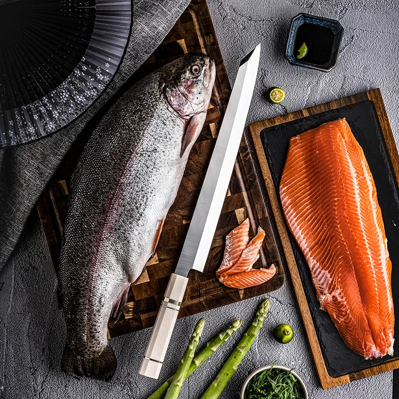Raw fish with a knife on a wooden cutting board, surrounded by asparagus and other ingredients.
