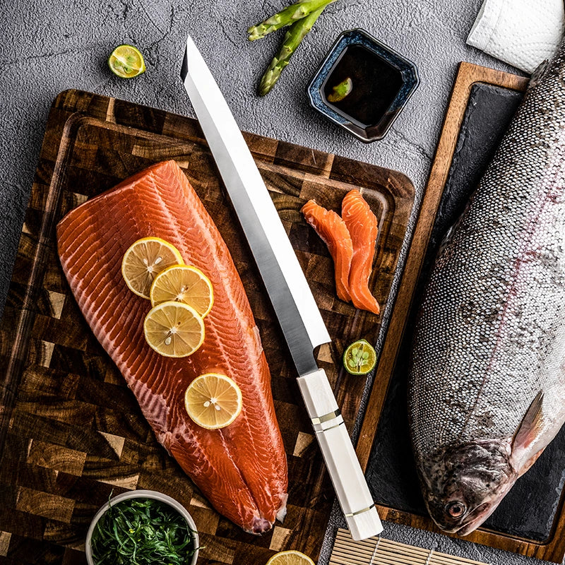 Raw salmon fillet with lemon slices on a wooden cutting board, accompanied by a knife and various garnishes.