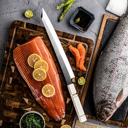 Raw salmon fillet with lemon slices on a wooden cutting board, accompanied by a knife and various garnishes.